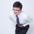 胃を押さえる男性