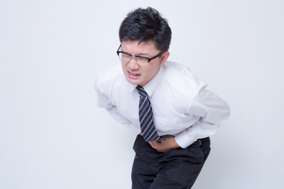 胃を押さえる男性